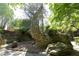 Unique stone dragon sculpture with stone landscaping nestled among mature trees and greenery at 107 Silo Dr, Chapel Hill, NC 27514