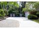 Wide driveway leading to a brick home with a unique gated entrance, surrounded by lush greenery at 107 Silo Dr, Chapel Hill, NC 27514