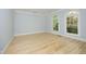 An empty room with hardwood floors and arched windows overlooking greenery at 107 Silo Dr, Chapel Hill, NC 27514