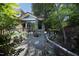 Exterior stone elevation featuring a brick walkway, lovely landscaping, and glass sunroom at 107 Silo Dr, Chapel Hill, NC 27514