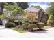Well-maintained brick home boasting lush landscaping, mature trees, and a welcoming circular driveway at 107 Silo Dr, Chapel Hill, NC 27514