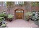 Inviting front entrance with a double wooden door, brick archway, and decorative potted plants at 107 Silo Dr, Chapel Hill, NC 27514