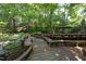 Scenic wooden pathway winds through landscaped backyard to peaceful pagoda in this spacious outdoor haven at 107 Silo Dr, Chapel Hill, NC 27514
