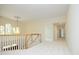 Open hallway with wood railing, neutral walls, carpet and a decorative light fixture at 107 Silo Dr, Chapel Hill, NC 27514