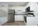 This bright kitchenette has stainless steel refrigerator, dark appliances, and light cabinets at 107 Silo Dr, Chapel Hill, NC 27514