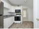 Kitchenette features a stainless steel refrigerator, dark appliances, and neutral tile floor at 107 Silo Dr, Chapel Hill, NC 27514