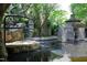 Backyard pond featuring a tiered stone water feature, Asian pagoda, and lush surrounding trees at 107 Silo Dr, Chapel Hill, NC 27514