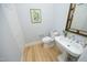 Powder room featuring pedestal sink, hardwood floors, and soft, neutral paint at 107 Silo Dr, Chapel Hill, NC 27514