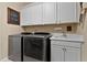 Functional laundry room with modern washer and dryer, sink, and ample storage cabinets at 112 Tanoak Ct, Durham, NC 27703