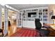 Office space featuring built-in bookshelves, a television, and glass paneled french doors to adjoining room at 112 Tanoak Ct, Durham, NC 27703