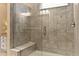 Close up of tiled shower with a glass door, a built-in seat, and modern fixtures at 112 Tanoak Ct, Durham, NC 27703