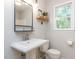 Bathroom featuring a pedestal sink, decorative shelf, and a view to the backyard at 113 Honeysuckle Ln, Durham, NC 27703