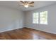 Bright bedroom featuring hardwood floors, ceiling fan and a large window for natural light at 113 Honeysuckle Ln, Durham, NC 27703