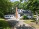 Charming home with a brick chimney, dormer windows, blue shutters, a white picket fence, and a two-car garage at 113 Honeysuckle Ln, Durham, NC 27703