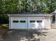 Detached two car garage with white doors and siding that matches the house at 113 Honeysuckle Ln, Durham, NC 27703