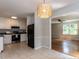 Bright kitchen with white cabinetry, stainless steel appliances, and view into the living room at 113 Honeysuckle Ln, Durham, NC 27703