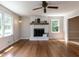Spacious living room featuring hardwood floors, a fireplace, and natural light from two windows at 113 Honeysuckle Ln, Durham, NC 27703