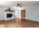 Bright living room with hardwood floors, white brick fireplace, wooden mantle and modern ceiling fan at 113 Honeysuckle Ln, Durham, NC 27703