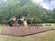Community playground featuring play structure with slides, swings, climbing wall, and picnic tables, all set in a natural, wooded setting at 113 Honeysuckle Ln, Durham, NC 27703