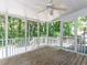 Cozy screened-in porch with wood flooring, ceiling fan, and views of the wooded backyard at 113 Honeysuckle Ln, Durham, NC 27703