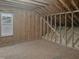 Unfinished attic space with exposed wooden framing and a window offering natural light at 113 Windy Creek Ln, Apex, NC 27502