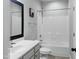 This bright bathroom has a tub with shower, a sink with vanity, and framed mirror at 113 Windy Creek Ln, Apex, NC 27502