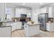 Modern kitchen boasts stainless steel appliances, white cabinetry, and a functional island at 113 Windy Creek Ln, Apex, NC 27502