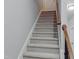 Carpeted stairway with wooden handrail and white trim leading to the upper level at 113 Windy Creek Ln, Apex, NC 27502
