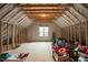 Unfinished attic space with wood framing, insulation, and a window for natural light at 1132 Heritage Knoll Dr, Wake Forest, NC 27587