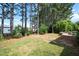Large grassy backyard features tall trees and a stone fire pit at 1132 Heritage Knoll Dr, Wake Forest, NC 27587