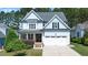 Charming two-story home with light blue siding, stone accents, an attached garage, and a well-manicured lawn at 1132 Heritage Knoll Dr, Wake Forest, NC 27587