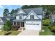 Charming two-story home with light blue siding, stone accents, an attached garage, and a well-manicured lawn at 1132 Heritage Knoll Dr, Wake Forest, NC 27587