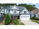 Charming two-story home with light blue siding, stone accents, an attached garage, and a well-manicured lawn at 1132 Heritage Knoll Dr, Wake Forest, NC 27587