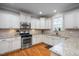 Well-lit kitchen boasts granite countertops, stainless steel appliances, and hardwood floors at 1132 Heritage Knoll Dr, Wake Forest, NC 27587