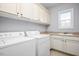 Convenient laundry room featuring modern washer, dryer, ample counter space, and cabinets at 1132 Heritage Knoll Dr, Wake Forest, NC 27587