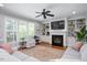 Spacious living room with a fireplace, built-in shelving, and large windows at 1132 Heritage Knoll Dr, Wake Forest, NC 27587