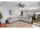 Open concept living room with hardwood floors, a ceiling fan, and access to the kitchen and dining area at 1132 Heritage Knoll Dr, Wake Forest, NC 27587