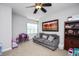 Living room with cozy gray sofa, area rug, natural light, playroom and bookshelves at 1132 Heritage Knoll Dr, Wake Forest, NC 27587