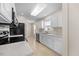 Well-lit kitchen with stainless appliances, white cabinets, tile flooring and view of eating area at 11340 Involute Pl # 100, Raleigh, NC 27617