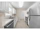 Bright kitchen with stainless appliances, white cabinets, tile floors and a view to another room at 11340 Involute Pl # 100, Raleigh, NC 27617
