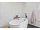 Bright bathroom with sleek, modern standalone tub and white accents at 115 Nuttree Way, Durham, NC 27713