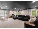 Spacious living room with large sectional sofa, projector, and abundant natural light through large windows at 115 Nuttree Way, Durham, NC 27713