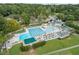 Community pool with swimming lanes, lounge chairs, umbrellas, and a clubhouse surrounded by mature trees at 115 Nuttree Way, Durham, NC 27713