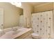 Bright bathroom with a marble countertop sink and tropical themed shower curtain at 119 Marykirk Pl, Garner, NC 27529