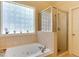Bright bathroom featuring a glass block window, soaking tub, and separate glass shower stall at 119 Marykirk Pl, Garner, NC 27529