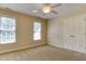 Neutral bedroom with two windows, a ceiling fan, and a double door closet at 119 Marykirk Pl, Garner, NC 27529