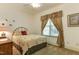 Cozy bedroom featuring a brass bed frame and a window with patterned drapes at 119 Marykirk Pl, Garner, NC 27529