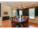Traditional dining room with hardwood floors, wainscoting, decorative chandelier, and large windows at 119 Marykirk Pl, Garner, NC 27529