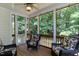 Relaxing screened porch with wicker chairs and peaceful views of the surrounding nature at 119 Marykirk Pl, Garner, NC 27529