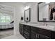 Bathroom with granite countertops, dark wood cabinets, framed mirrors, and a view to the bedroom at 120 Bramble Ln, Clayton, NC 27527